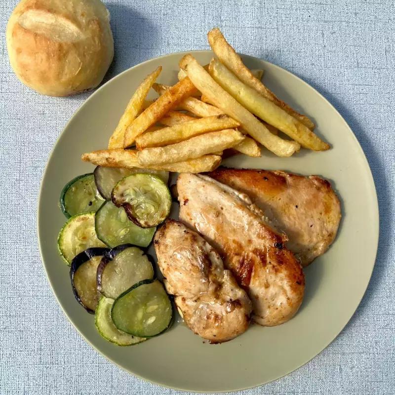 Pollo grillado con papas fritas.