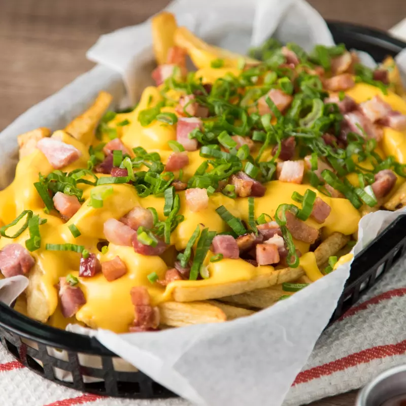 Papas c/ Cheddar, panceta y verdeo